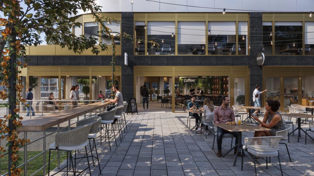 Terras met mensen die genieten van eten en drinken voor het gebouw aan de H.J.E. Wenckebachweg.